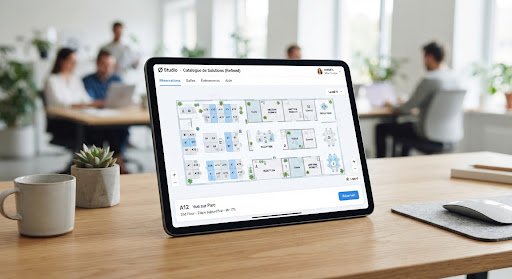 Tablette posée sur un bureau, affichant le plan d'un étage et les postes réservables dans une application Ø Studio