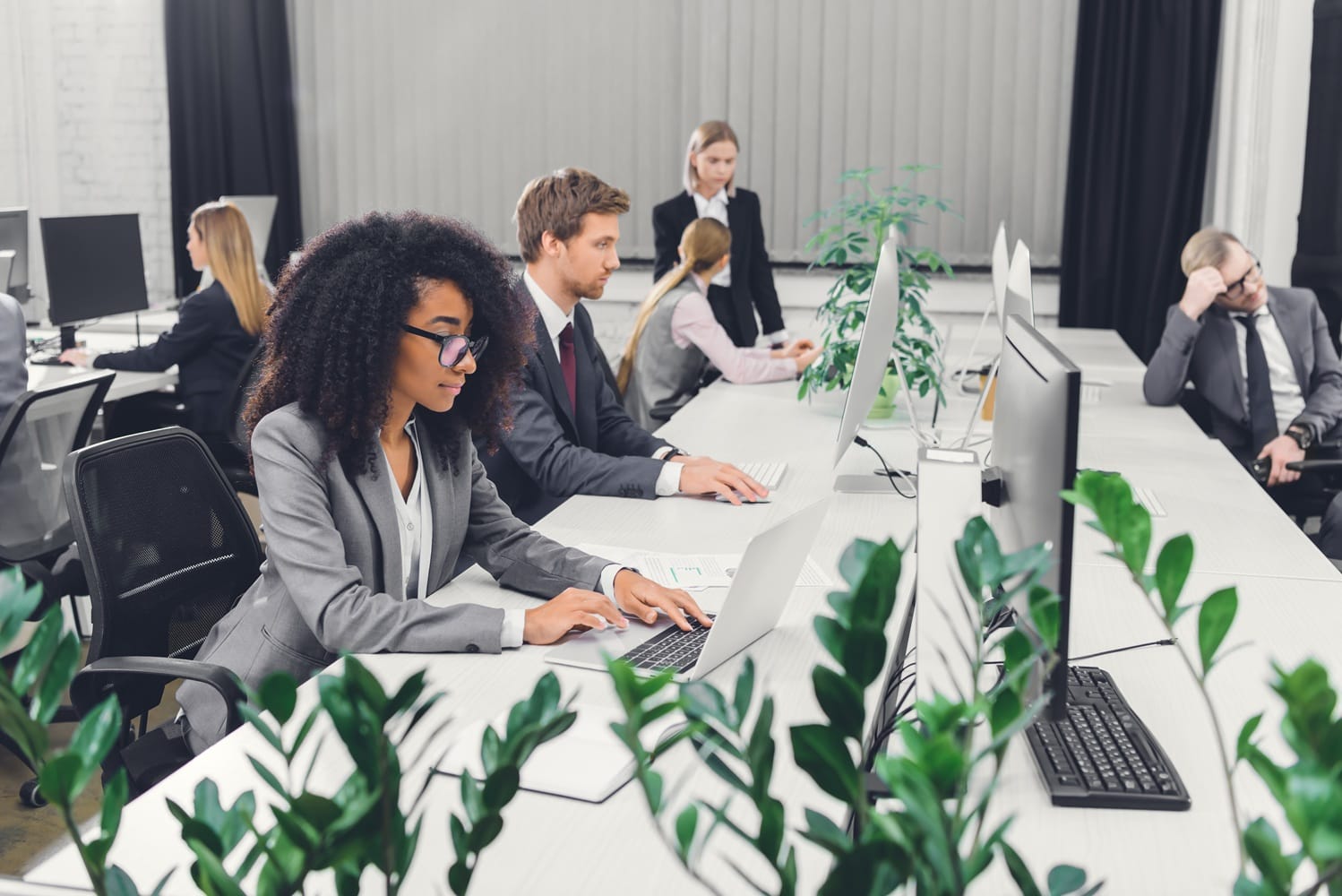 professional multiethnic young businesspeople working with digital devices in open space office